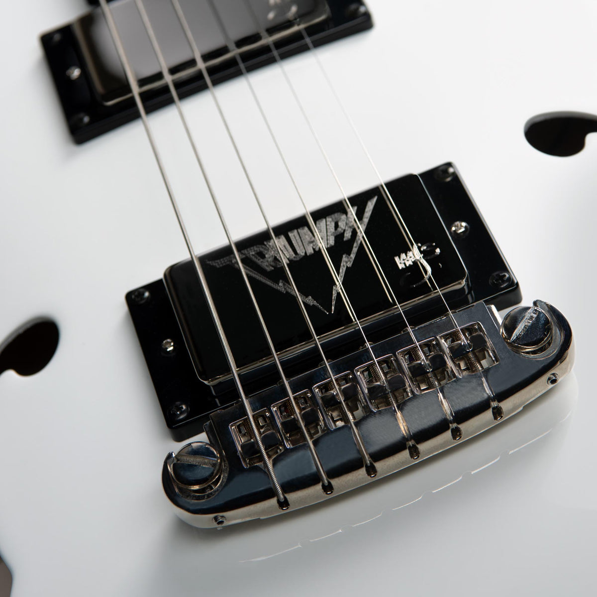Close-up of the Godin Rik Emmett Premiere Electric Guitar—a limited edition model by Godin—featuring six strings, a black logo-embossed pickup, and a chrome bridge.