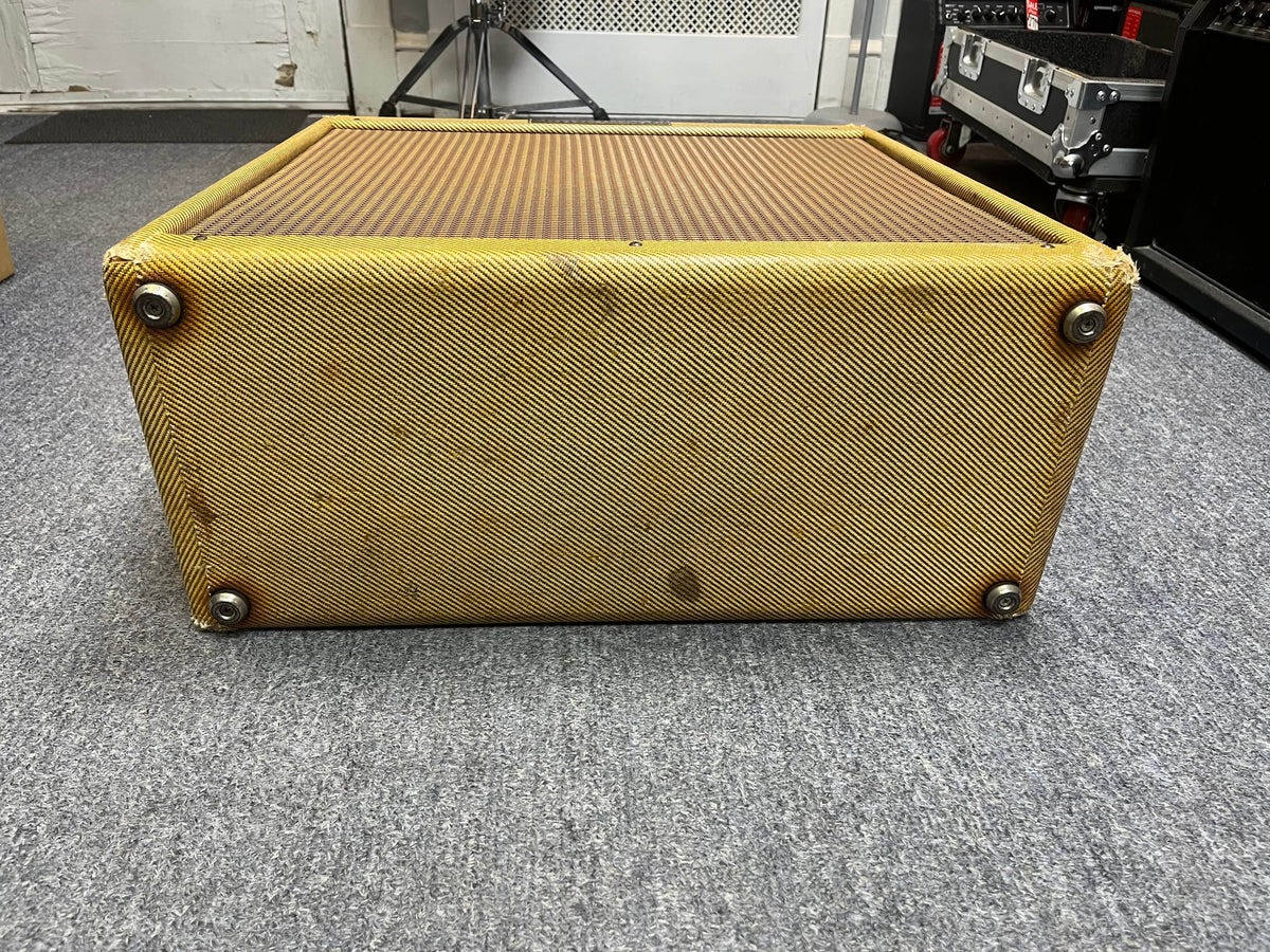 A Fender 1957 Bassman 5F6 Narrow Panel 40-Watt 4x10" Guitar Combo with flight case rests on its side on a gray carpet in a music studio.
