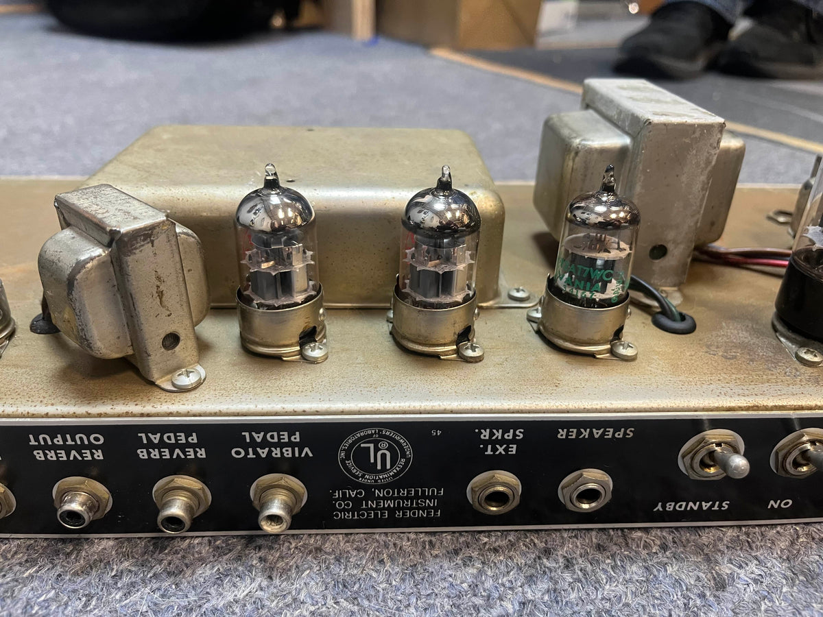 Close-up of the back panel on a 1965 Fender Deluxe Reverb AB763 (Pre-CBS Blackface, Serial A 06439) highlights its vacuum tubes, input/output jacks, and detailed control labels.