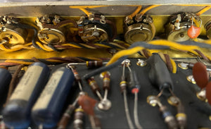 Close-up of vintage electronic components—resistors, capacitors, wires, and potentiometers—arranged on a circuit board from a 1965 Fender Deluxe Reverb AB763 Pre-CBS Blackface (Serial A06439) by Fender.