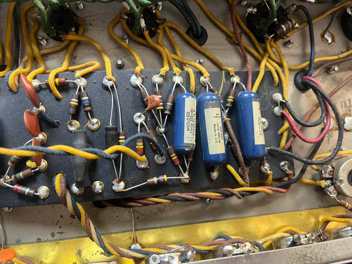 Close-up of vintage electronic components—resistors, capacitors, and wiring—mounted on the circuit board inside a 1965 Fender Deluxe Reverb AB763 Pre-CBS Blackface (serial A 06439) by Fender.