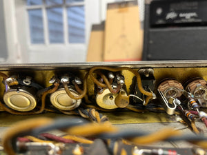 Close-up of vintage electronic components and wiring inside a metal enclosure from a 1965 Fender Super Reverb - Black Panel - "Player’s Dream" Restoration, offered by Guitars on Main.