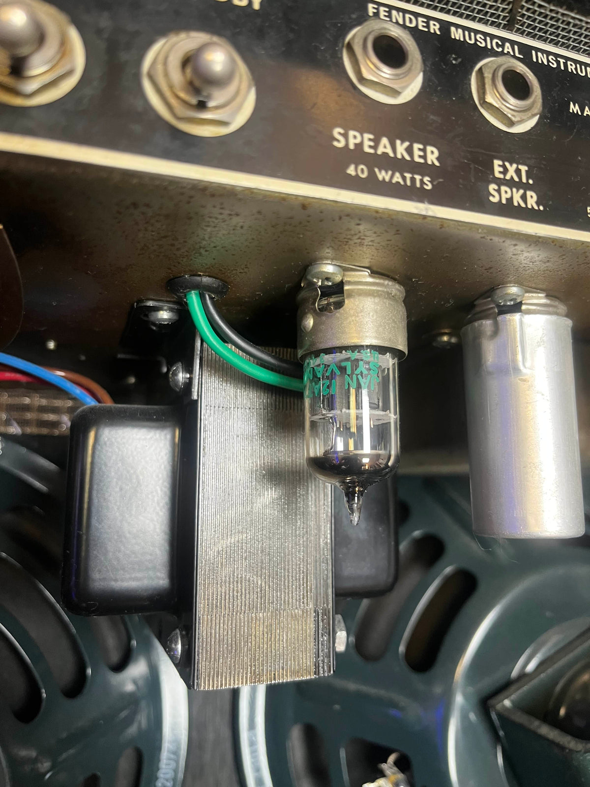 Close-up of an electronic vacuum tube and wiring inside a 1965 Fender Super Reverb - Black Panel - "Player’s Dream" Restoration by Guitars on Main, highlighting metal components and labeled speaker connections capturing the iconic Blackface sound.