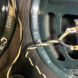 Close-up of two green speaker frames with wiring and markings from a 1965 Fender Super Reverb - Black Panel, available for local pickup at Guitars on Main.
