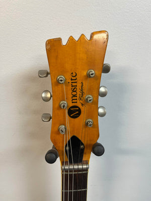 Close-up of the 1967 Mosrite Mark I Vintage Guitar headstock, displaying six tuning pegs, the Mosrite logo, and "of California" text on a wooden finish—a true symbol of American guitar heritage.