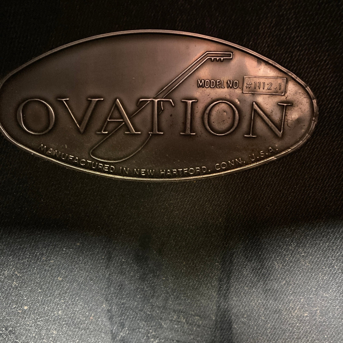 Close-up of an Ovation 1976 1112-1 acoustic guitar label, made in the USA, showcasing its New Hartford craftsmanship and signature Lyrachord rounded back for enhanced sound. Includes case.