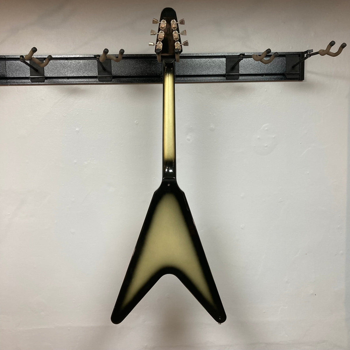 1979 Gibson Flying V Silverburst guitar mounted on a wall, highlighting its unique shape and vintage appeal.