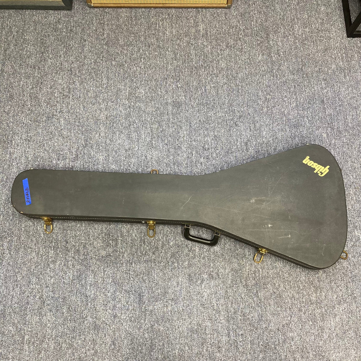 1979 Gibson Flying V Silverburst w/Case on carpet, showcasing its vintage charm and minor blemishes, available at Guitars on Main.