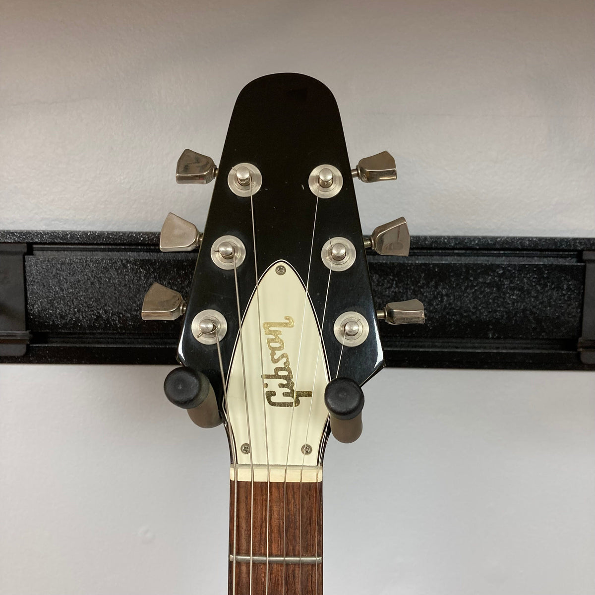1979 Gibson Flying V Silverburst guitar head close-up, showcasing strings and tuning pegs, highlighting its vintage craftsmanship.