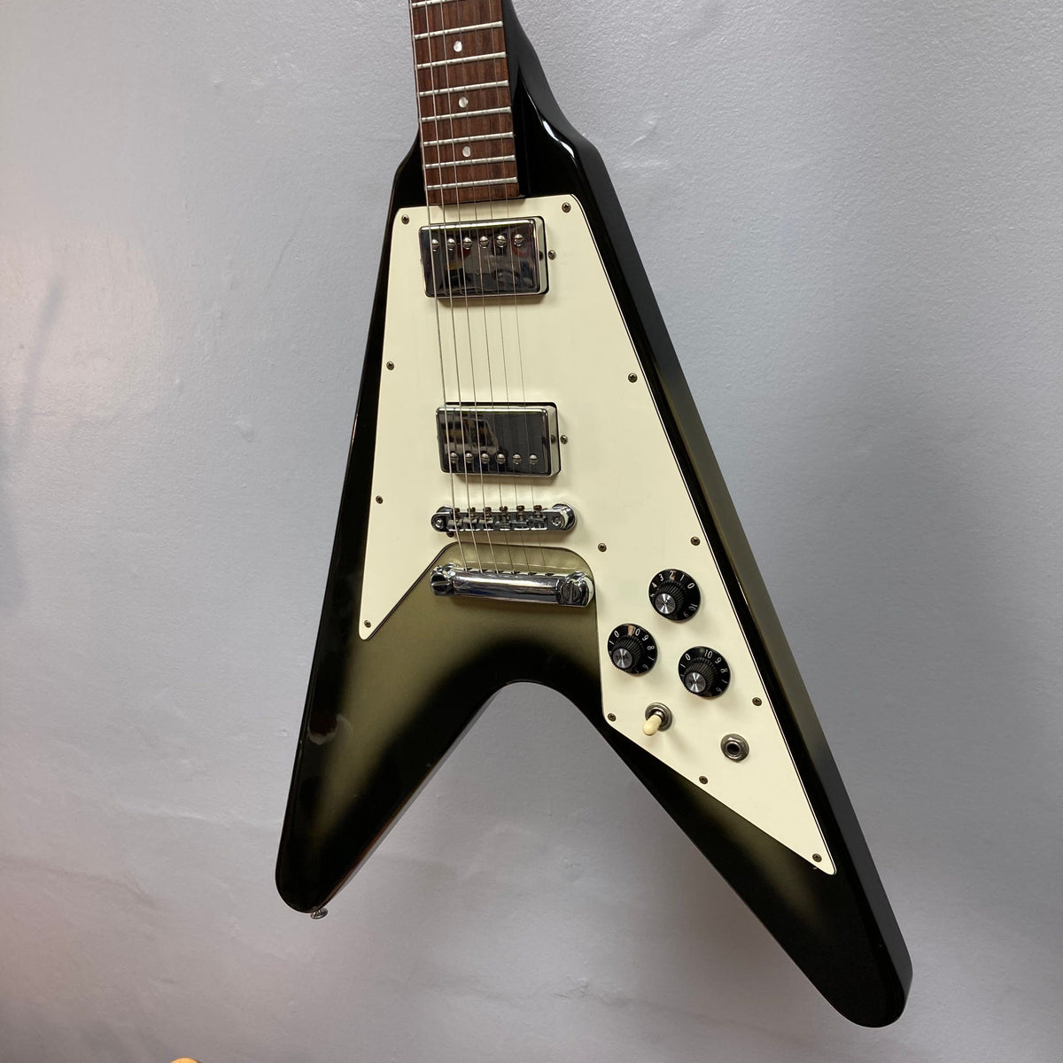 1979 Gibson Flying V Silverburst guitar with minor blemishes, strings close-up, and original case.
