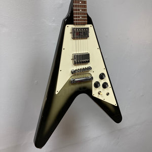 1979 Gibson Flying V Silverburst guitar displayed on a wall, featuring minor blemishes and original case.