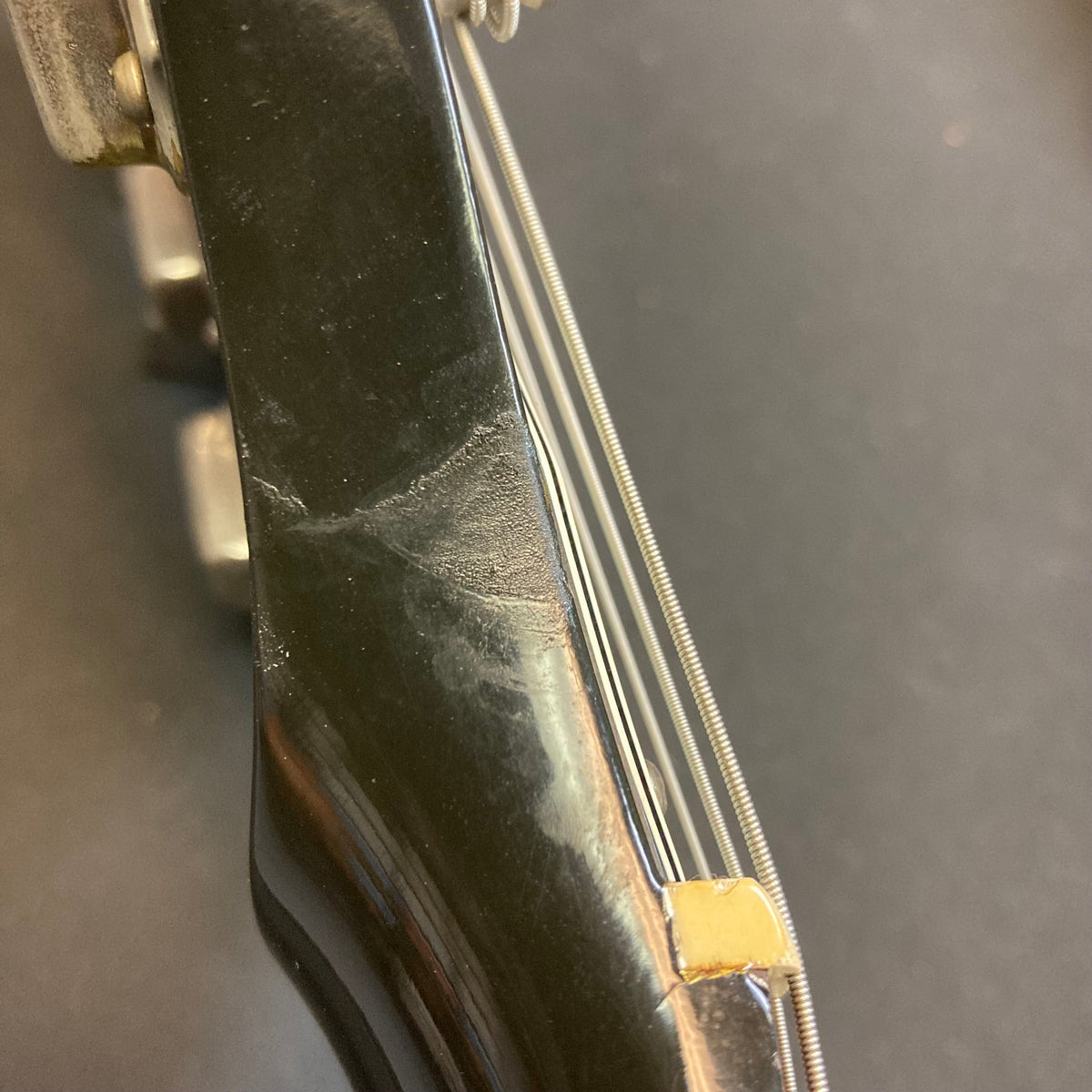 Close-up of the 1979 Gibson Flying V Silverburst guitar neck and strings, showcasing its vintage craftsmanship and exceptional condition, with the original black leather case included.