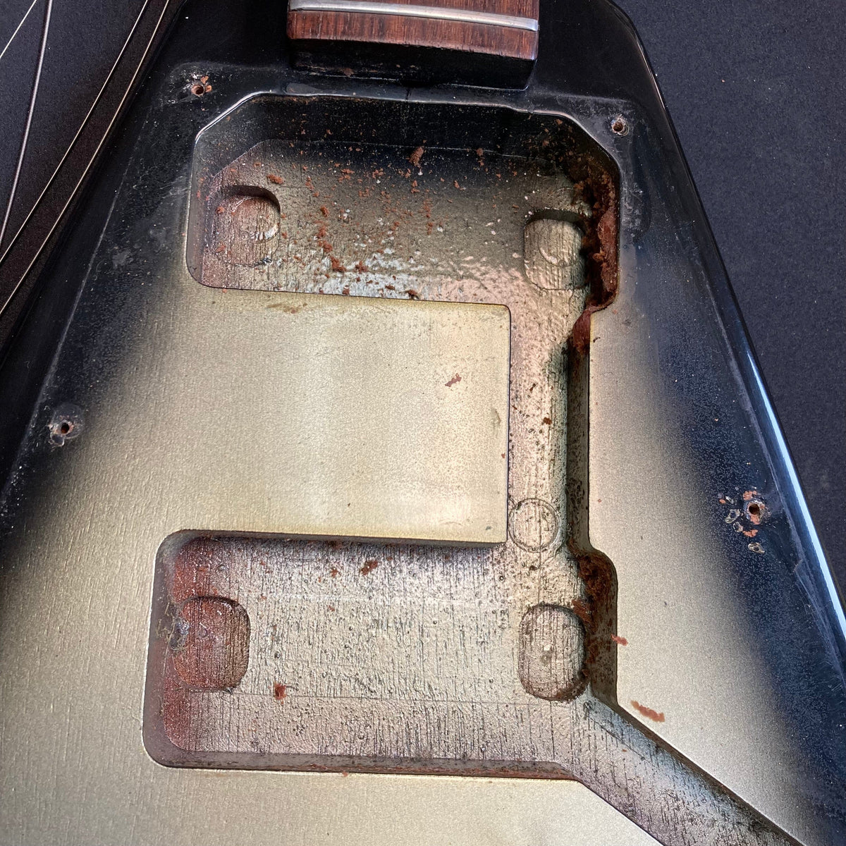 1979 Gibson Flying V Silverburst guitar with minor blemishes and brown handle, showcasing a metal surface; includes original case.