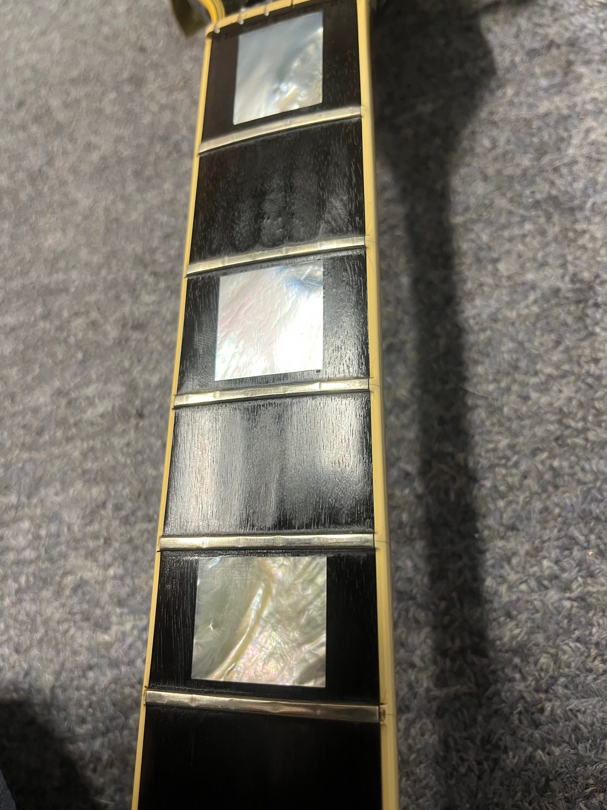 1980 Gibson Les Paul Custom fretboard close-up with block inlays, highlighting its authentic vintage wear and craftsmanship. Strings and frets removed.