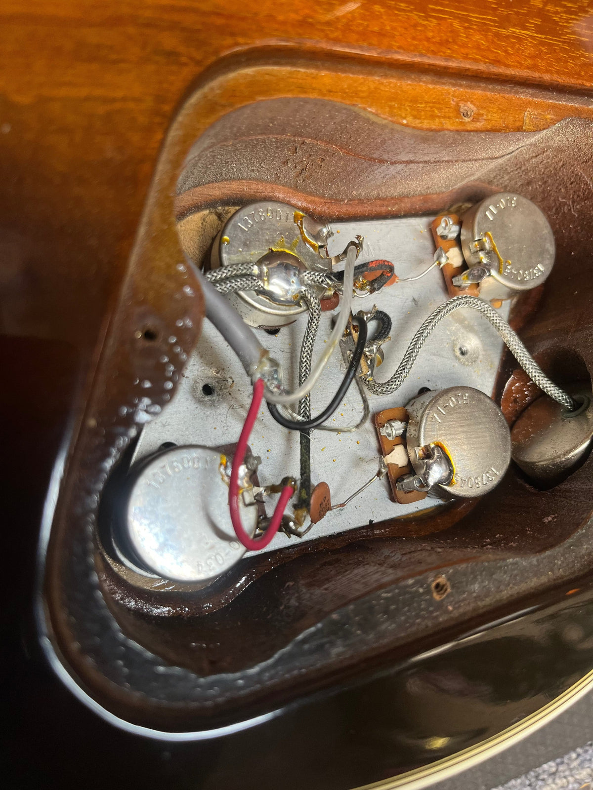Close-up of the electronics cavity in a 1980 Gibson Les Paul Custom – Tobacco Sunburst w/OHSC, showing potentiometers, wiring, and shielding inside the wooden body by Gibson.