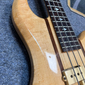 Close-up of a 1982 B.C. Rich Eagle Bass—USA Made—showing its natural wood grain, neck-through body, decorative fretboard inlays, original electronics, and part of a pickup; a professionally set up vintage classic.