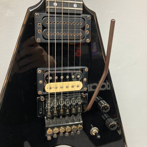 Close-up of a 1992 Carvin Ultra V USA electric guitar featuring a Kahler Steeler tremolo and MJ-wound Seymour Duncan DCJ humbucker on its sleek black body, with bridge, control knobs, output jack, and tremolo arm in view.