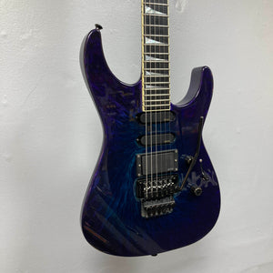 Featuring a mesmerizing Eerie Dess Swirl finish in dark blue with a glossy sheen, the 1995 Jackson SL1 Soloist Custom Shop electric guitar boasts two humbucker pickups, a locking tremolo bridge, and sleek black hardware. This exceptional Jackson instrument comes complete with its case and is captured here against a plain white wall.