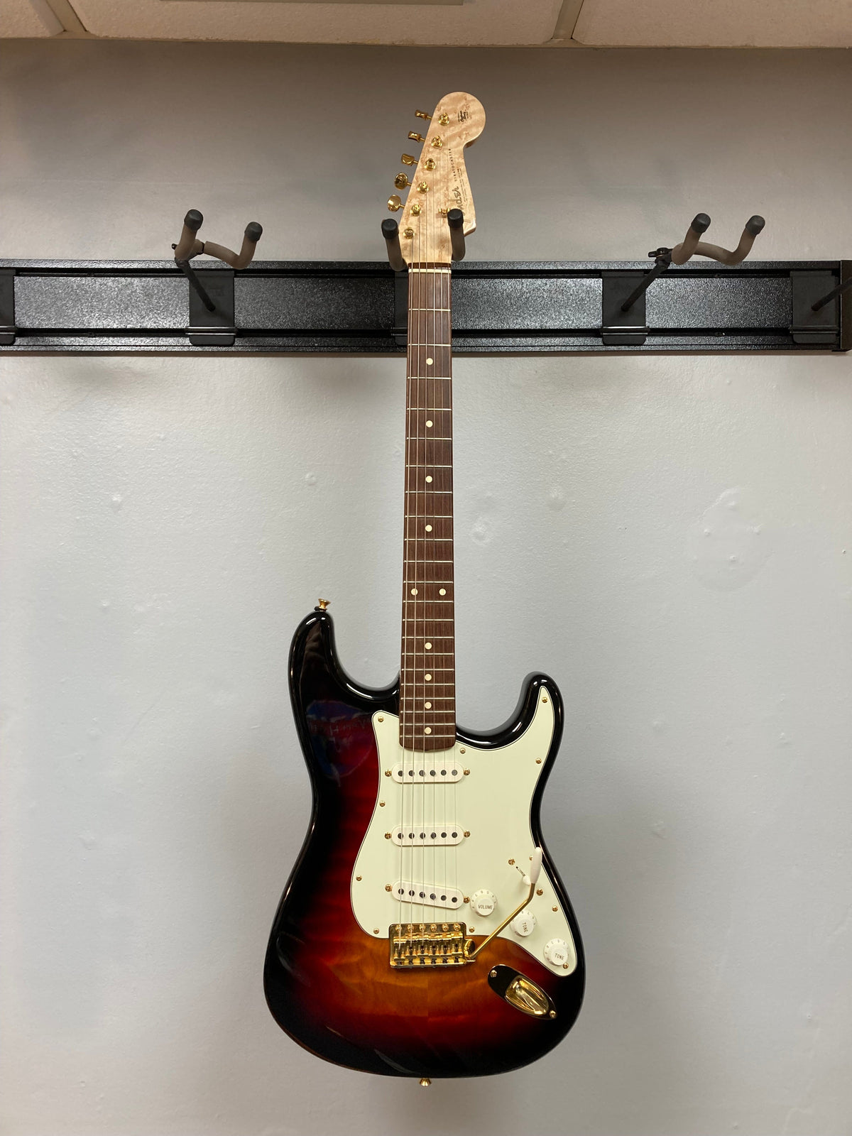 Fender Custom Shop 1960s FMT Stratocaster 1998 displayed on a rack, showcasing its detailed craftsmanship and collectible status.