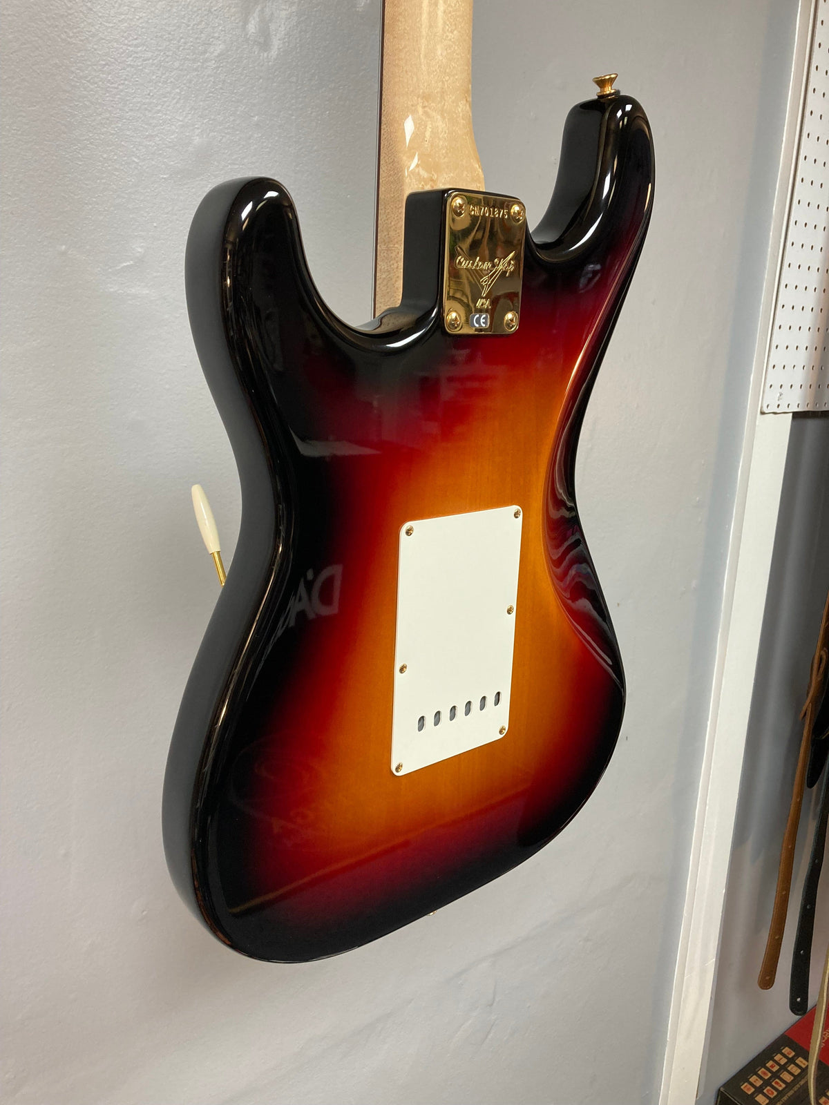 Fender Custom Shop 1960s FMT Stratocaster 1998 displayed on a white wall, showcasing meticulous craftsmanship and iconic woodwork.