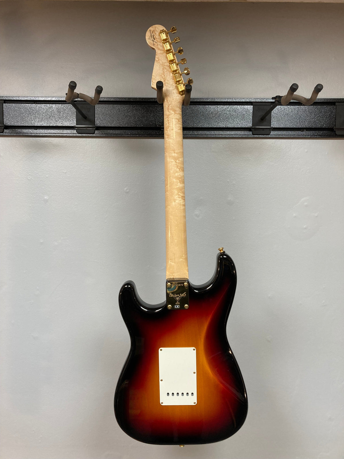 Fender Custom Shop 1960s FMJ Stratocaster 1998 guitar displayed on a wall hook.