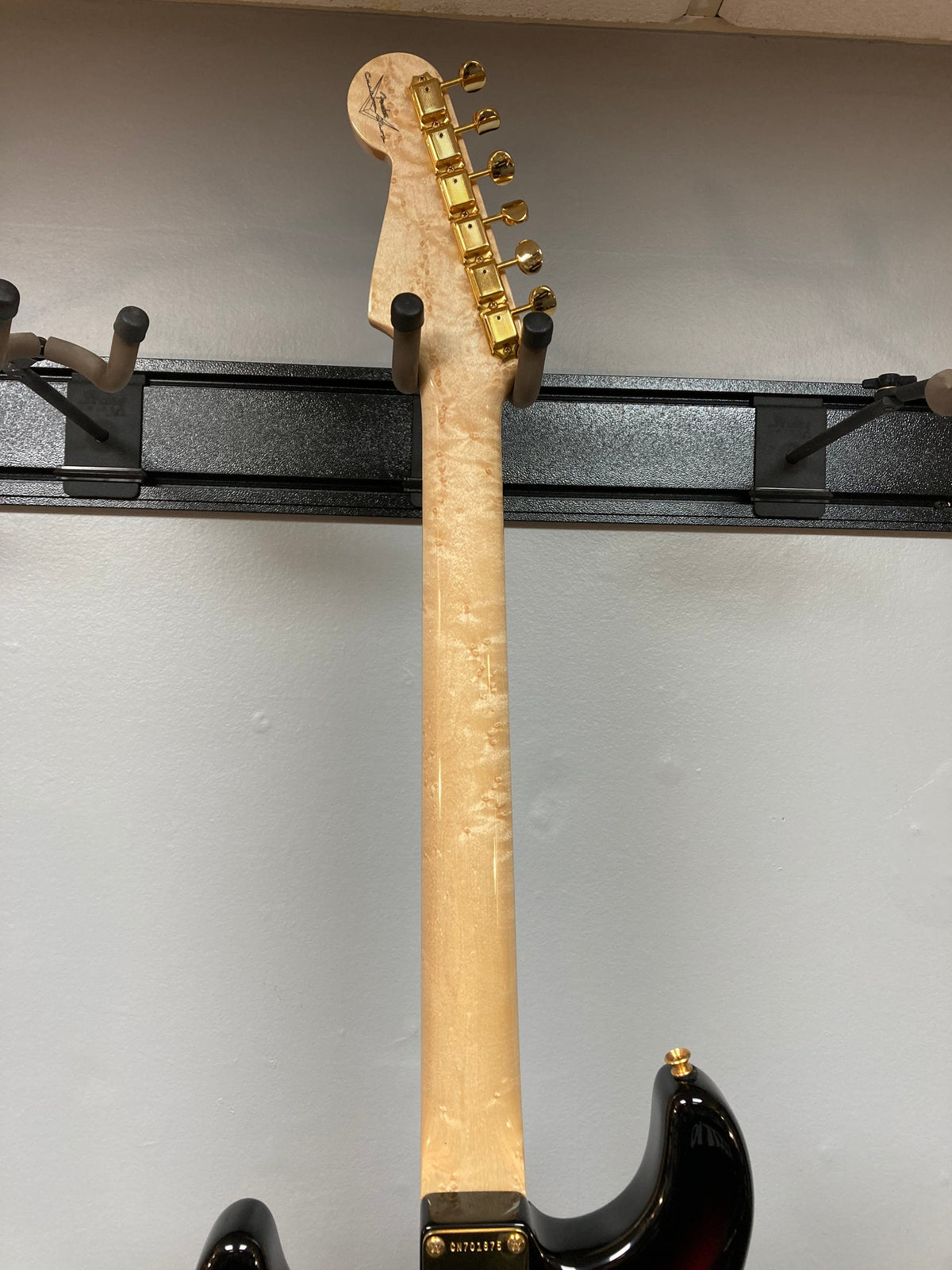 Fender Custom Shop 1960s FMT Stratocaster 1998 on a rack, showcasing vintage design and craftsmanship.