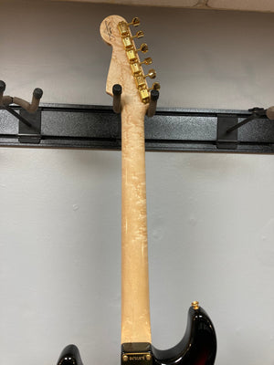 Fender Custom Shop 1960s FMT Stratocaster 1998 on a rack, showcasing vintage design and craftsmanship.