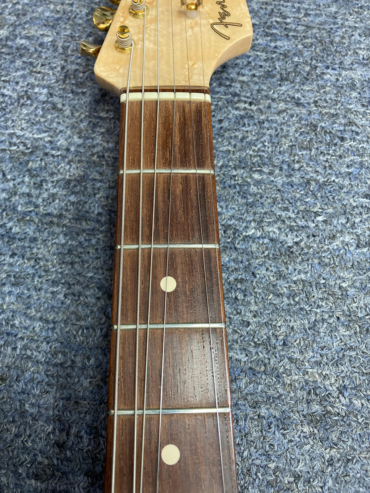Close-up of the Fender Custom Shop 1960s FMT Stratocaster 1998 guitar neck, showcasing detailed craftsmanship and strings.