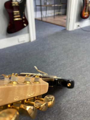 Close-up of a 1998 Fender Custom Shop 1960s FMJ Stratocaster guitar, showcasing meticulous craftsmanship and iconic woodwork.