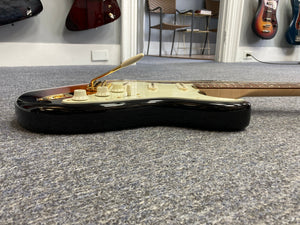 Fender Custom Shop 1960s FMT Stratocaster 1998 w/Case on carpet, showcasing meticulous craftsmanship and vintage allure.
