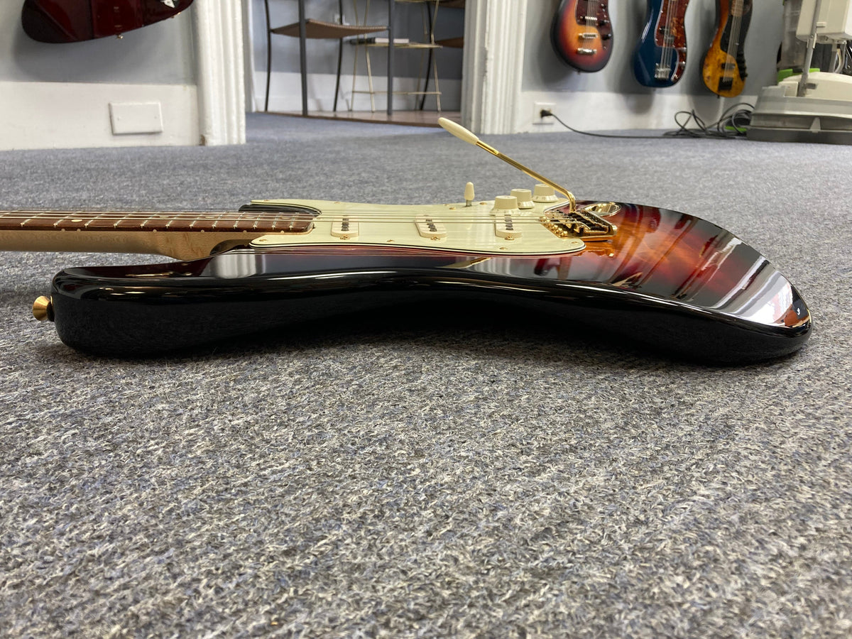 Fender Custom Shop 1960s FMJ Stratocaster 1998 on floor, showcasing meticulous craftsmanship and original features, including case candy and certificate of authenticity.