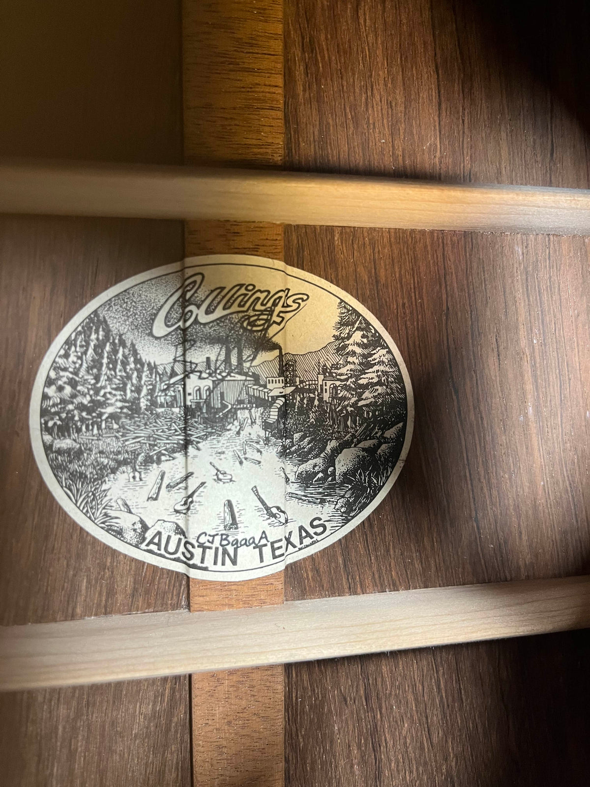 Inside the wooden body of this 2005 Collings CJ BaA guitar, a label reads "Collings, Austin Texas," with a black-and-white building and tree illustration, reflecting its craftsmanship in Brazilian rosewood and Adirondack spruce.