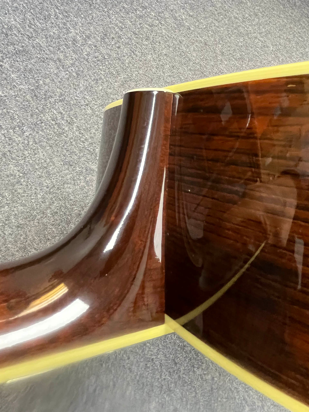 Close-up of the neck joint on a glossy 2005 Collings CJ BaA (Brazilian Rosewood & Adirondack Spruce) acoustic guitar, highlighting the smooth transition and cream binding between neck and body.