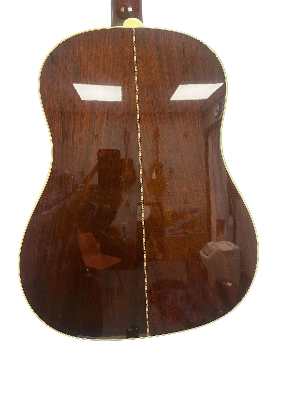The back of the 2005 Collings CJ BaA—Brazilian Rosewood & Adirondack Spruce—shows a polished dark wood finish, decorative center strip, and light binding, reflecting light and a person to highlight its elegance.