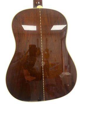 The back of the 2005 Collings CJ BaA—Brazilian Rosewood & Adirondack Spruce—shows a polished dark wood finish, decorative center strip, and light binding, reflecting light and a person to highlight its elegance.