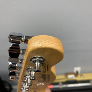 Close-up of a Fender 2007 Standard Telecaster MIM Midnight Wine Red headstock with chrome tuning pegs, showing part of the brand and model info against a blurred background.