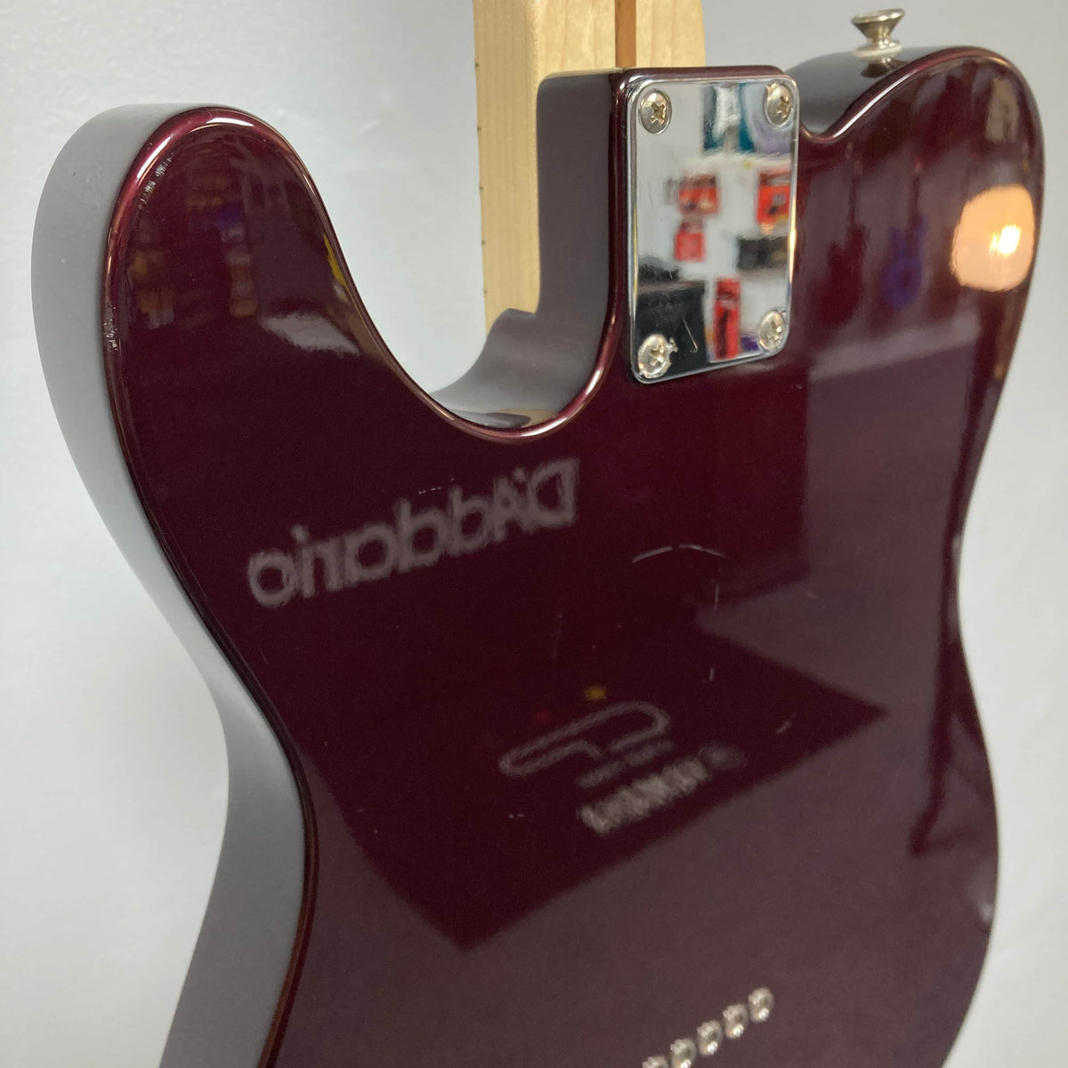 A close-up of the back of a 2007 Fender Standard Telecaster MIM Midnight Wine Red electric guitar with a glossy finish, featuring a metal neck plate and reflected "D’Addario" text on the body.