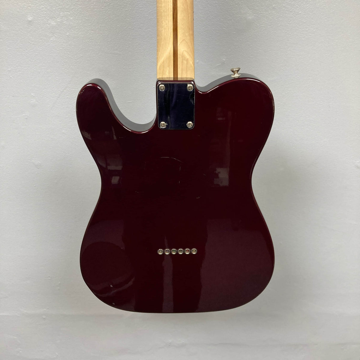 The image shows the back of a 2007 Fender Standard Telecaster MIM Midnight Wine Red by Fender, featuring a glossy maroon body, light neck attached with a metal plate and four screws, set against a plain light gray wall.