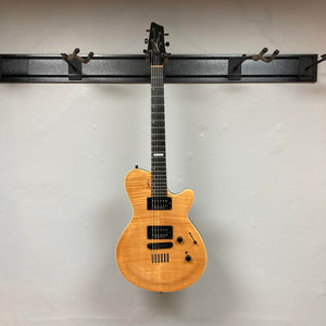 A 2009 Godin Summit CT with a carved flame maple cap by Godin, featuring a natural wood finish, hangs on a wall-mounted rack with several empty hooks.