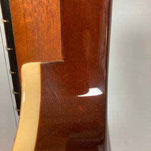 Close-up of the neck joint on a 2009 Godin Summit CT w/Carved Flame Maple Cap electric guitar, featuring cream binding and showing the smooth neck-to-body transition against a plain background.