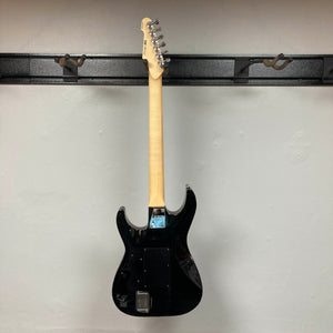 A 2019 ESP USA M-II in Purple Haze Burst, an American-made electric guitar by ESP, is hanging on a wall-mounted rack, shown from the back with the neck and tuning pegs visible.