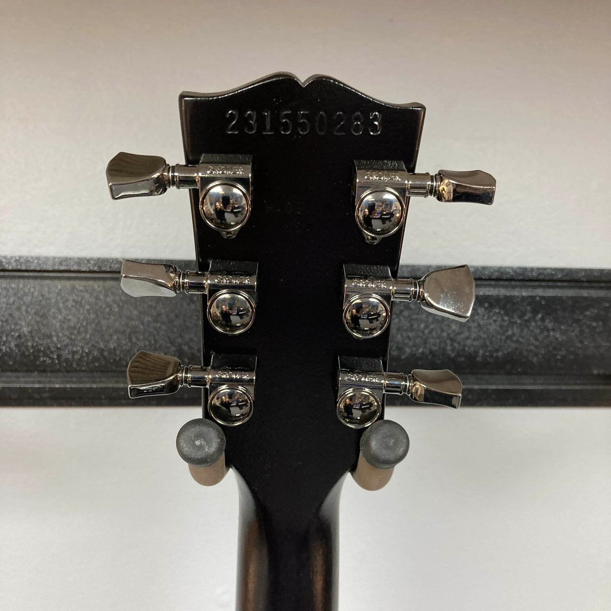 Back of a 2025 Gibson Les Paul Studio Modern in Smokehouse Satin, showing six tuning pegs and engraved serial "231550289"—a classic detail from Gibson. Includes Gator Molded Case.