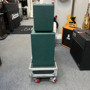 A 2005 Divided by 13 RSA 31 head with matching 2x12 cabinet and flight case is stacked on a rolling cart in a music store, surrounded by guitars and amplifiers. Local pickup for this Divided by 13 product is available.