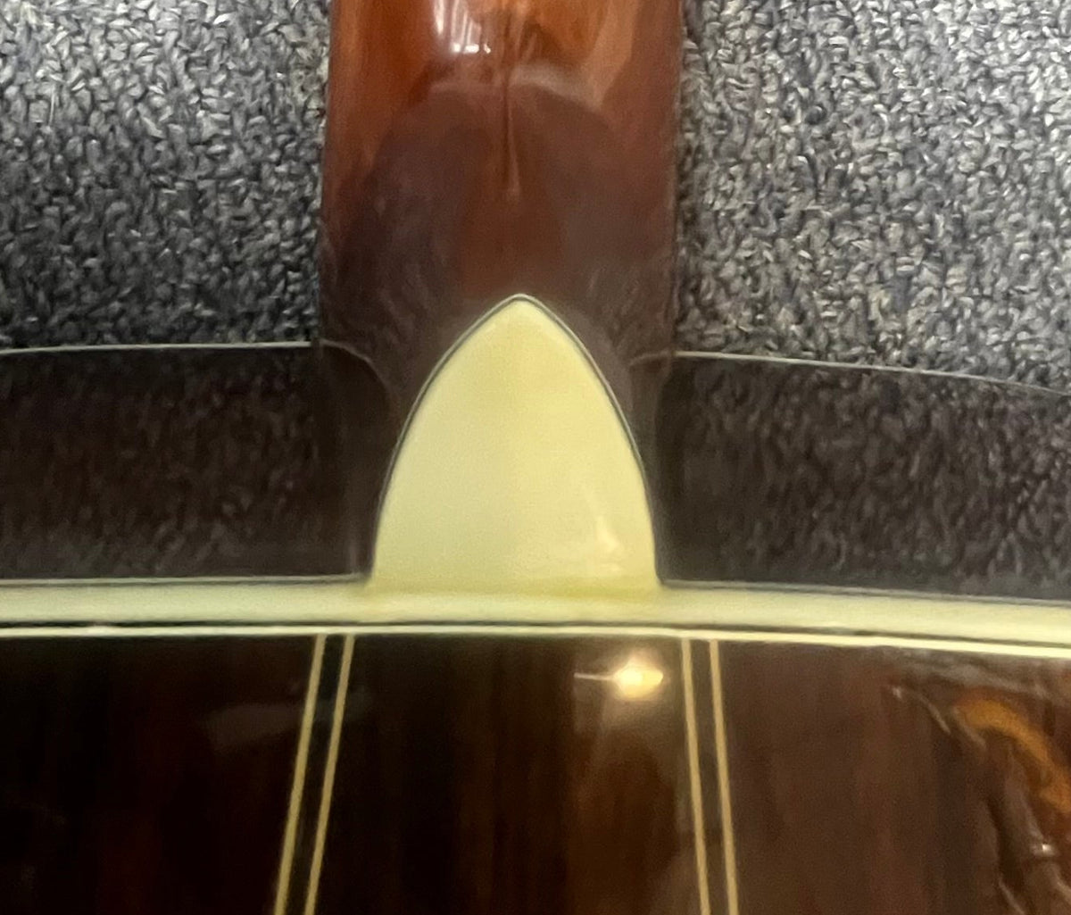 Close-up of the back of a Vintage Sigma DR-35 Acoustic Guitar w/case (Made in Japan) by Sigma, inspired by the Martin D-35, showing neck joint, cream heel cap, and decorative wood binding.