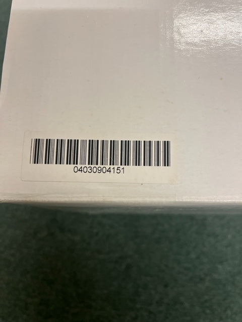 A white box with a barcode sticker showing 04030904151, possibly containing a Monster Power AVS 2000 PRO Professional Reference Automatic Voltage Stabilizer by Monster Power, rests on a green surface.