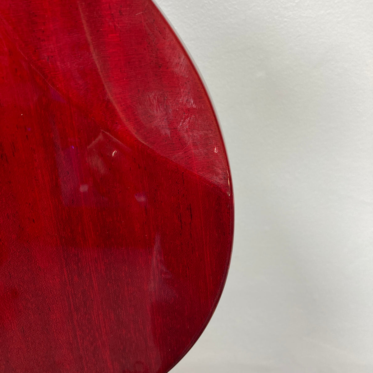 Close-up of the back of an ESP Standard Eclipse Transparent Cherry Red guitar by Esp, showing visible scratches and a small dent—includes case.
