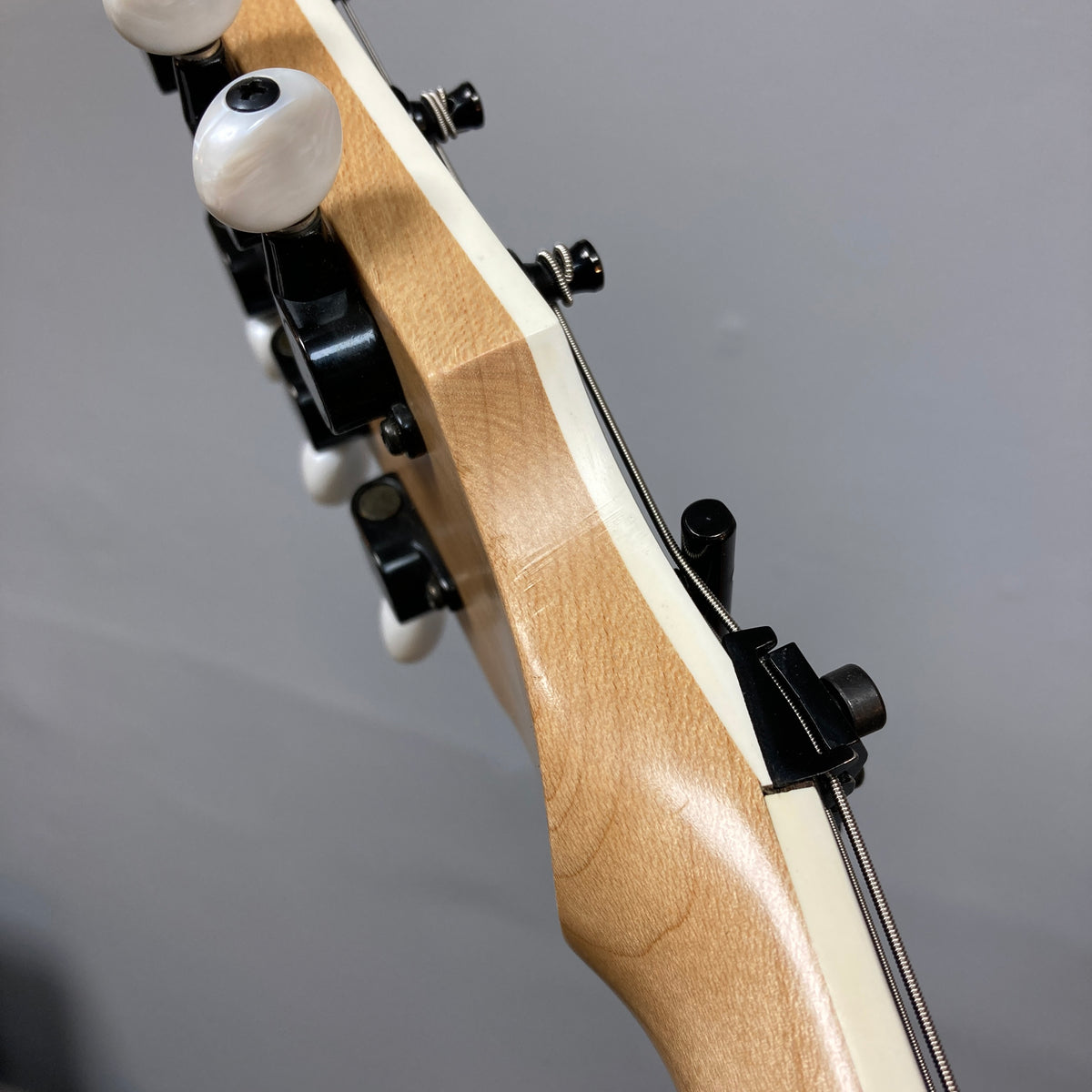 Close-up of an ESP Standard Eclipse Transparent Cherry Red headstock, displaying tuning pegs, nut, and part of the neck against a plain background.