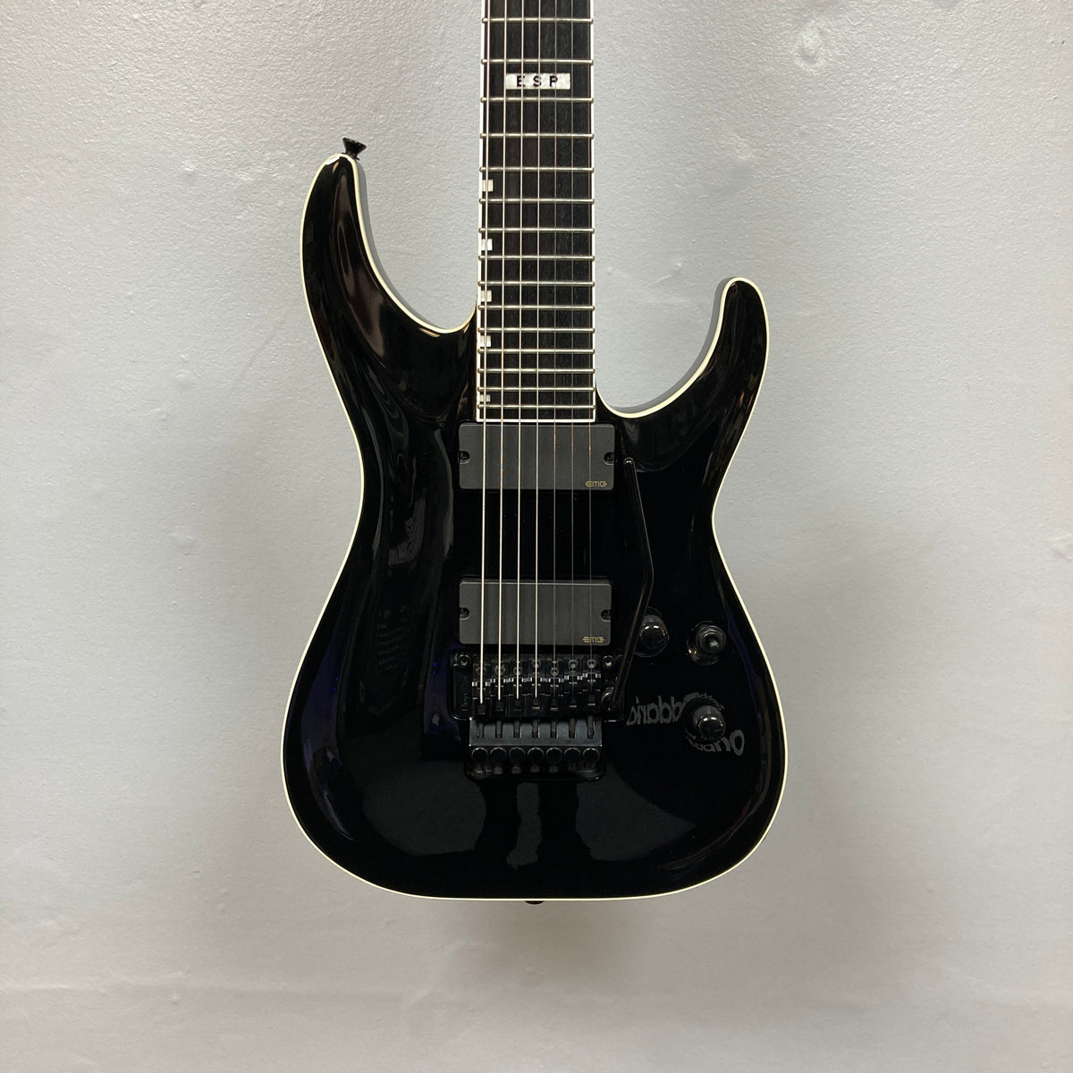 An ESP E-II Horizon FR-7 Black 7-string electric guitar by ESP with a glossy finish, Floyd Rose bridge, two pickups, white body binding, and whammy bar is pictured against a plain white background.