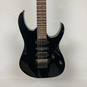An Ibanez Prestige RG1570 electric guitar in Cosmic Blue with a double cutaway body, three pickups, Wizard Prestige neck, tremolo bridge, and control knobs is shown with its case against a plain white background.