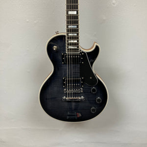 A used Schecter Solo-II Custom electric guitar in Trans Black Burst finish with chrome hardware and Pasadena pickups, displayed against a light gray wall; includes case.